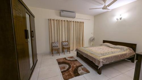 a bedroom with a bed and a ceiling fan at Room in Uttara Sector 3 Apartment in Bāiljuri