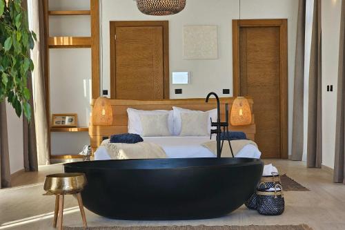 BrcaにあるHigh-End Villa with Private Beach Accessの黒いバスタブとベッドのあるバスルーム