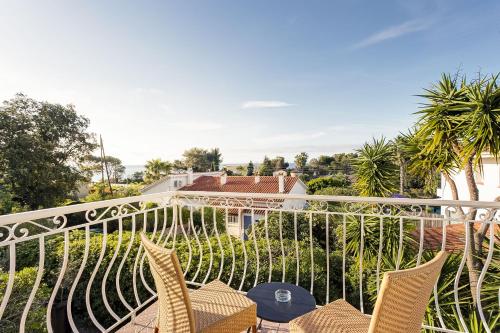 a balcony with chairs and a view of a house at HOTEL LA QUIETUDE in Les Issambres