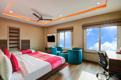 a bedroom with two beds and a desk and windows at The IVY Grand Hotel - 5 Minutes from Connaught Place and New Delhi Railway Station With Free Secured Parking in New Delhi