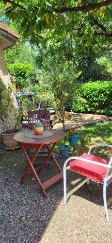 a picnic table with a chair and a bench at Chambre spacieuse climatisée sur la route des plages in Eysines