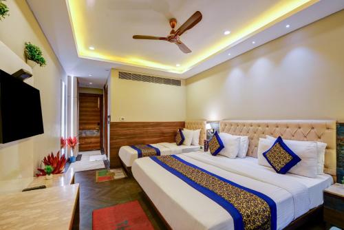two beds in a hotel room with a ceiling fan at The IVY Grand Hotel - 5 Minutes from Connaught Place and New Delhi Railway Station With Free Secured Parking in New Delhi