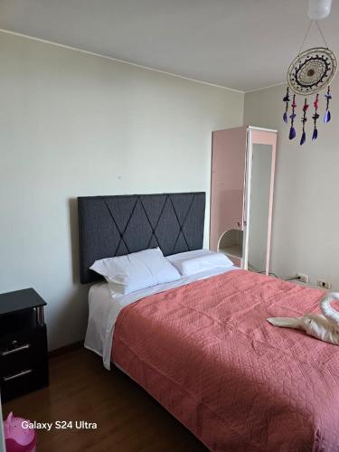 a bedroom with a large bed with a red blanket at DEPARTAMENTO en AREQUIPA JOSE LUIS BUSTAMANTE in Arequipa