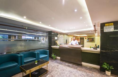 a man sitting at a bar in a restaurant at The IVY Grand Hotel - 5 Minutes from Connaught Place and New Delhi Railway Station With Free Secured Parking in New Delhi
