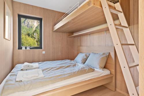 a small bedroom with a bunk bed and a ladder at Eksklusiv hytte i naturskjønne omgivelser, Lofoten in Storøya