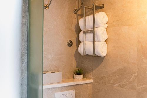 a bathroom with a pile of towels on a wall at Apartment Eva in Murter