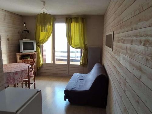 un salon avec un canapé et une télévision dans l'établissement Studio cabine 26m² avec balcon sud-ouest à Barcelonnette - FR-1-804-45, à Barcelonnette