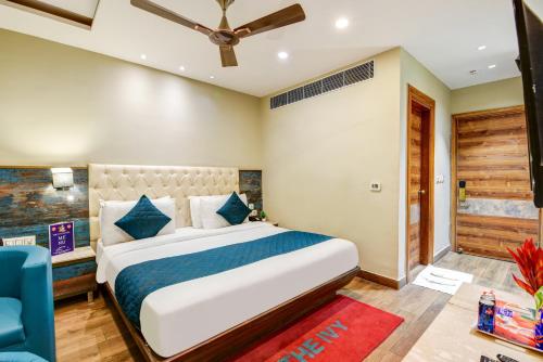 a bedroom with a large bed and a blue chair at The IVY Grand Hotel - 5 Minutes from Connaught Place and New Delhi Railway Station With Free Secured Parking in New Delhi