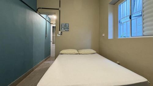 a large bed in a room with a window at Suíte 05 • Praia das Pitangueiras in Guarujá