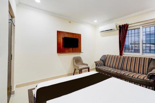 a living room with a bed and a couch at Hotel O Airport Road Near Leela Mahal in Tirupati