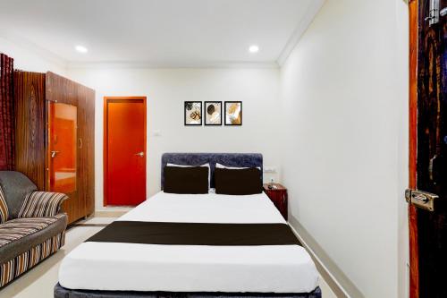 a bedroom with a bed and a couch at Hotel O Airport Road Near Leela Mahal in Tirupati