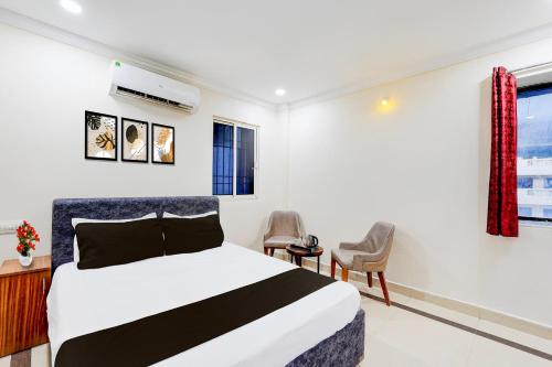 a hotel room with a bed and a chair at Hotel O Airport Road Near Leela Mahal in Tirupati