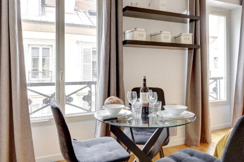 une salle à manger avec une table et des chaises et une fenêtre dans l'établissement Bluestay 237 - Superbe Appartement à Paris, à Paris