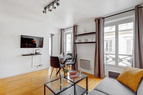 un salon avec un canapé et une table dans l'établissement Bluestay 237 - Superbe Appartement à Paris, à Paris