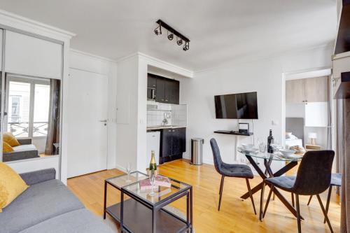 un salon avec un canapé, une table et des chaises dans l'établissement Bluestay 237 - Superbe Appartement à Paris, à Paris