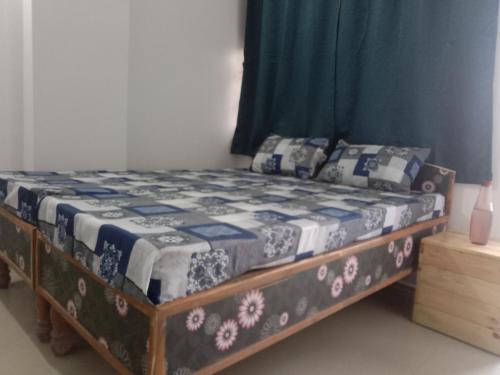 a bed with a blue and white quilt on it at Family Room in Indore