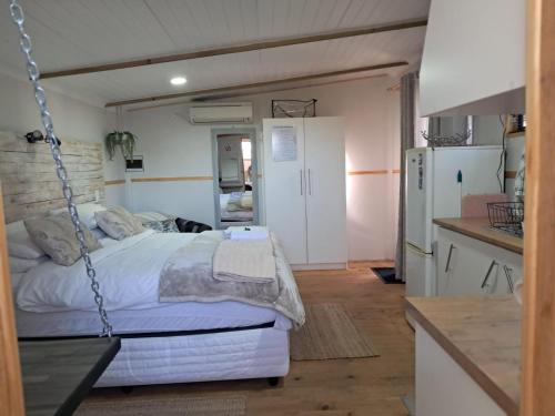 a bedroom with a swing bed and a kitchen at Villa Mariss Guesthouse in Kraaifontein