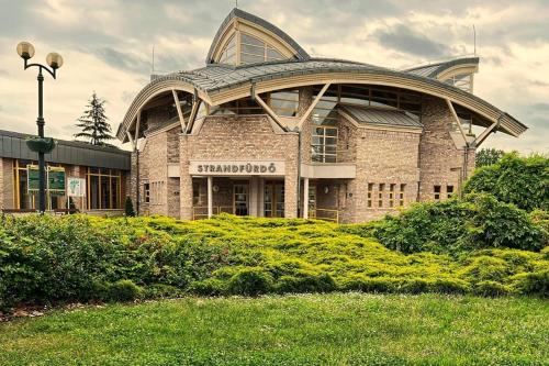 un grande edificio in mattoni con tetto rotondo di Termál Apartman a Tiszaújváros