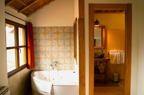 a bathroom with a tub and a sink at La Montaña Mágica Hotel Rural in Vibaño