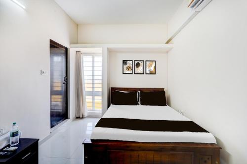 ein Schlafzimmer mit einem großen Bett in einem Zimmer in der Unterkunft Super Collection O Sholinganallur Chennai Formerly Nimalan Residenc in Chennai