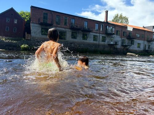 two children playing in the water in a river at Mörrum River Residences in Mörrum