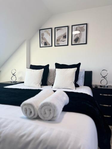 a bedroom with two beds with towels on them at The 37 Suites in Ponders End