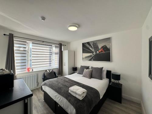 a bedroom with a large bed and a window at The 37 Suites in Ponders End