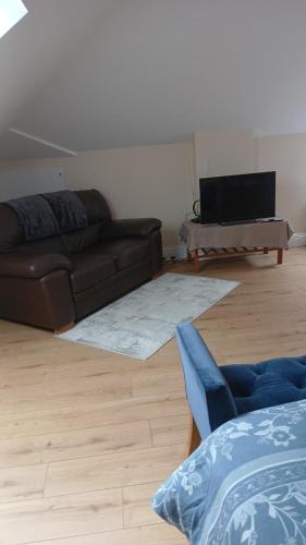 a living room with a couch and a table at Modern Countryside apartment Killmallock Lodge in Enniscorthy