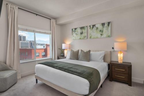 a bedroom with a large bed and a window at Deluxe 2BR Convention Center Gym, Pool, Htub, Pkg in Salt Lake City