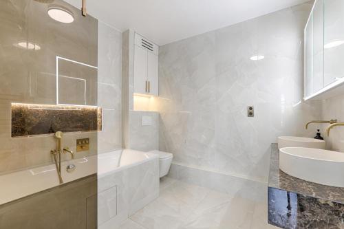 une salle de bain avec un lavabo, une baignoire et des toilettes dans l'établissement Appartement de luxe avec terrasse 3BR Levallois, à Levallois-Perret
