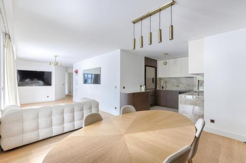 un salon avec une table et une cuisine dans l'établissement Appartement de luxe avec terrasse 3BR Levallois, à Levallois-Perret