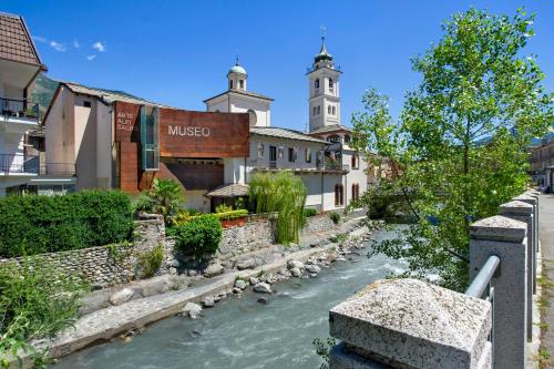 a river in the middle of a town with buildings at Welcome Home 1 Meana di Susa in Meana di Susa
