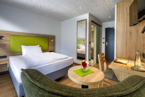 a hotel room with a bed and a table and chairs at Hotel-Gasthof Rangau in Ansbach