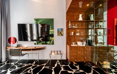 a room with a table and a shelf with glasses at Hotel Calimala Milano in Milan
