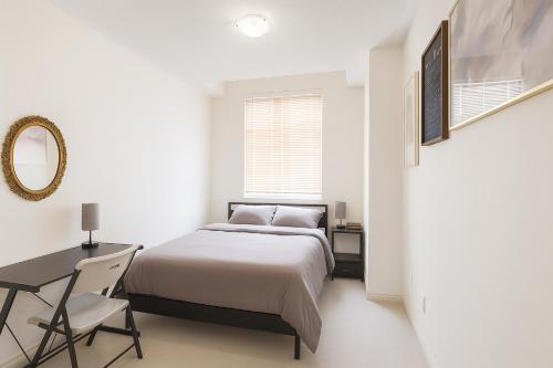 a bedroom with a bed and a desk and a mirror at 2024 Built Stylish 3BR Cambridge Townhouse with Free Parking, WiFi, Full Kitchen, Laundry, Only 8 Mins to African Lion Safari! Perfect for Family Travel, Group Trips or Work Stays! in Cambridge