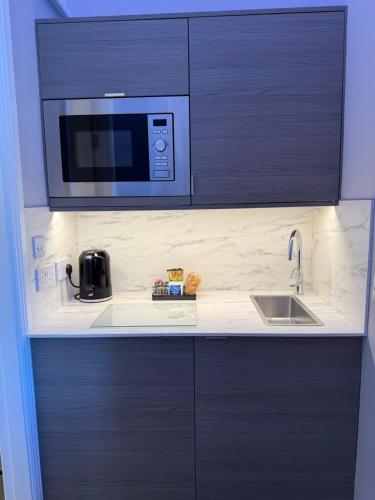 a kitchen with a sink and a microwave at Linen Bank in Linlithgow