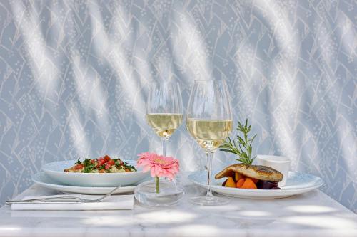 a table with two glasses of wine and a plate of food at Icce Borbirtok - Wine, Dine & Rest in Monoszló