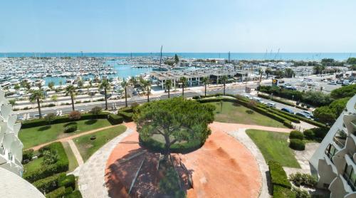 a park with a tree in the middle of a city at Studio chic & cosy vue mer, clim, parking in La Grande-Motte