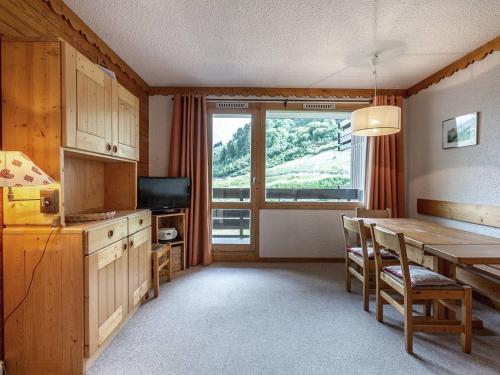 une cuisine avec une table à manger et une grande fenêtre dans l'établissement Méribel Mottaret : Appart. Confortable 2 Ch, Balcon, Ski-In/Ski-Out - FR-1-355-50, à Méribel