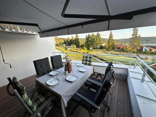 a table and chairs on a balcony with a view of a track at SNOW LAKE Lipno in Lipno nad Vltavou