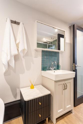 a bathroom with a sink and a mirror at Fun Kemptown Stay with Games Close To Seafront in Brighton & Hove