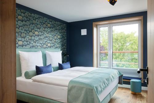 a bedroom with a bed with blue walls and a window at Pidder-Lyng Apartment 11 in Böhl