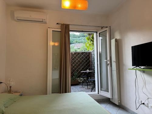 a bedroom with a bed and a sliding glass door at Ligo in Villanova dʼAlbenga