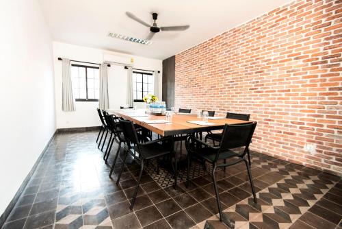 a dining room with a brick wall and a table and chairs at Aquarius Hotel and Urban Resort in Phnom Penh