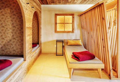 a room with two benches with red pillows on them at Natur-Genuss-Hotel Sonnasita in Faschina