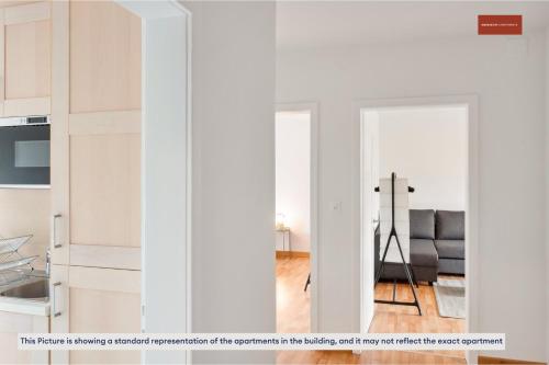 a kitchen with white cabinets and a living room at Zurich Style One Bedroom All Yours in Zürich