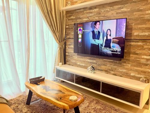a living room with a television on a brick wall at The JB House - A 5 Star Quality Home At Iskandar Puteri in Gelang Patah