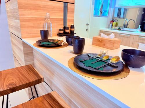 a kitchen counter with two plates of food on it at The JB House - A 5 Star Quality Home At Iskandar Puteri in Gelang Patah