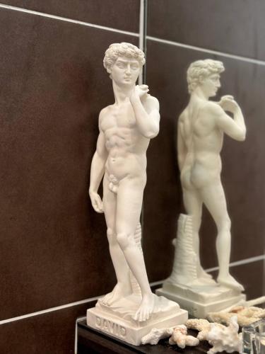 a white statue of a man standing next to a mirror at The JB House - A 5 Star Quality Home At Iskandar Puteri in Gelang Patah