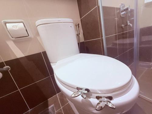 a white toilet in a bathroom with a shower at The JB House - A 5 Star Quality Home At Iskandar Puteri in Gelang Patah